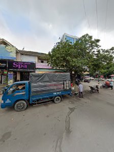 The image depicts a street scene in Thao Dien, Saigon, featuring a blue truck with a covered cargo area parked on the road. Nearby, there are building