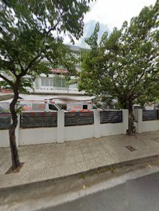 The image depicts a street scene in Thao Dien, Saigon. It features a sidewalk paved with light-colored tiles flanked by two mature trees with dense gr