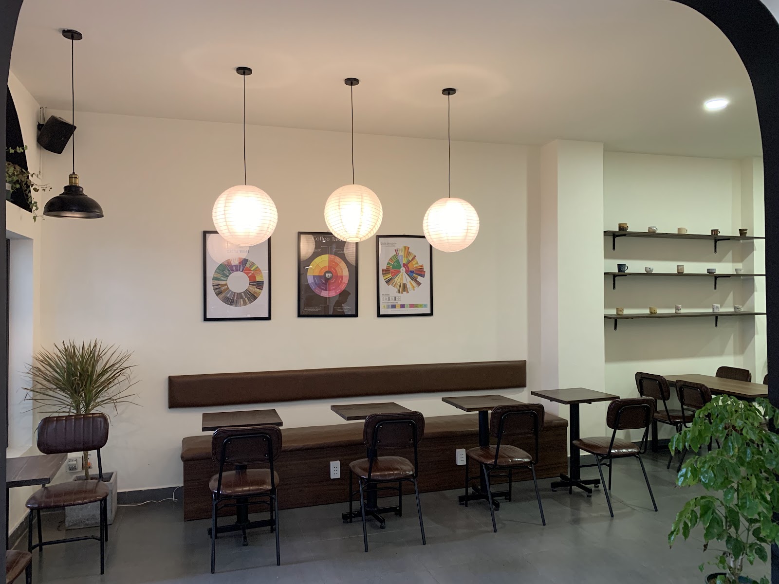 This image shows an interior view of a modern cafe or restaurant in Thao Dien, Saigon. The space features contemporary decor with hanging pendant ligh