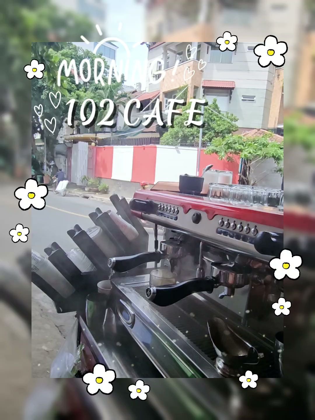 The image shows an outdoor view of a cafe named '102 Cafe' with the text 'Moringa!' overlaid on it, decorated with floral graphics and heart symbols.