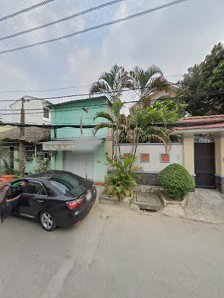 The image shows a residential area in Thao Dien, Saigon. There is a black car parked on the street and two houses with greenery around them.