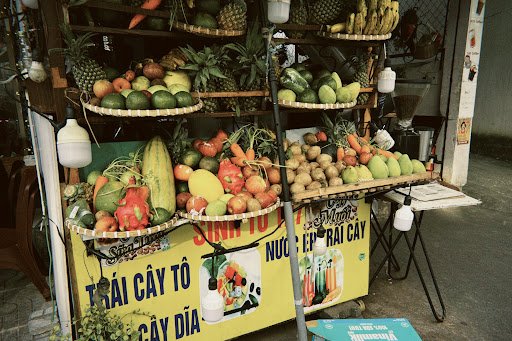 A fruit and vegetable stall displaying a variety of produce for sale on the street in Thao Dien, Saigon.