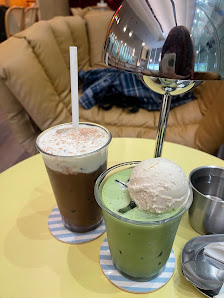 The image shows a table in an indoor setting with two drinks and some dessert items on it.