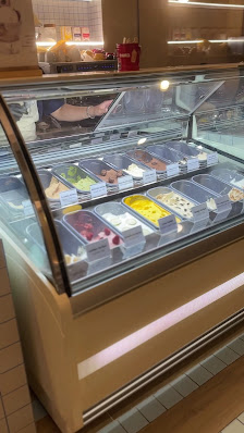 The image shows a display case in an interior setting likely within a food establishment such as a café or restaurant. The glass-fronted refrigerated