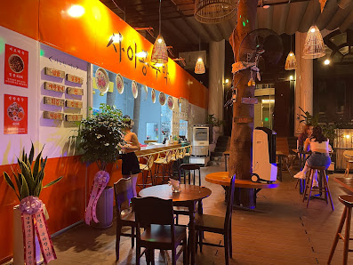 The image shows an interior view of a modern restaurant or bar in Thao Dien, Saigon. The space is well-lit with warm lighting and features wooden furn