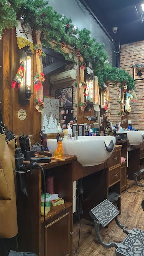 A beauty salon interior featuring wooden furniture, white ceramic sinks, large mirrors, and festive Christmas decorations including garlands, stocking