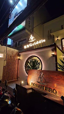The exterior of a restaurant named '8SGriddle' and 'KOREAN BBQ', with an illuminated signboard indicating the establishment's name.