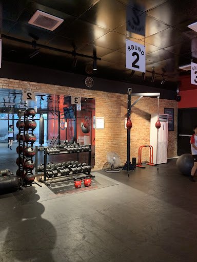 This image depicts an interior view of a gym or fitness center located in Thao Dien, Saigon. The space features exposed brick walls and modern industr