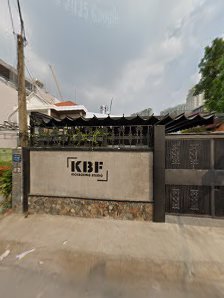 The image shows an exterior view of a building entrance labeled 'KBF' on the gate and wall.
