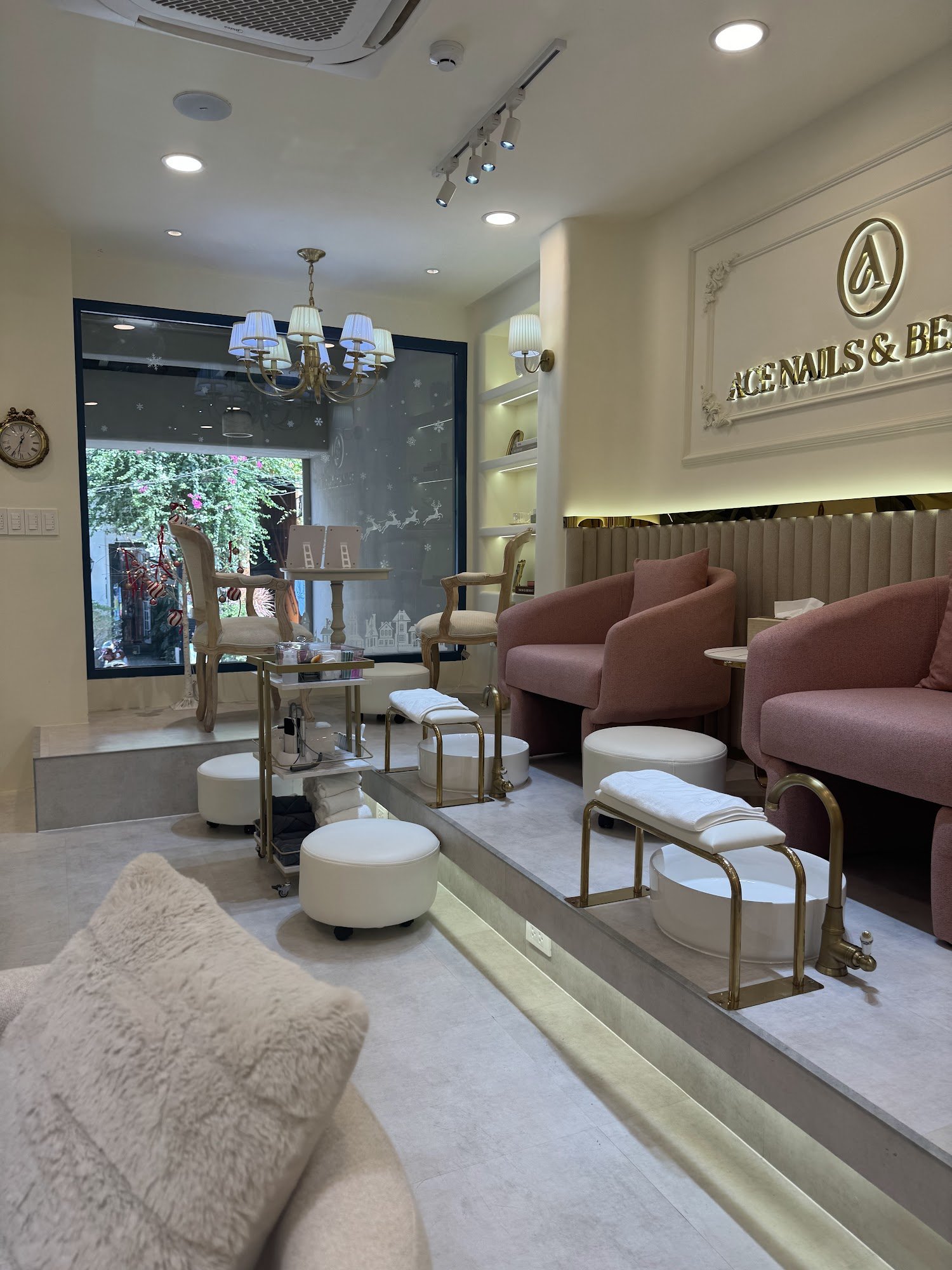 The image shows an interior view of a modern nail salon named 'ACE NAILS & BEAUTY'. The space is well-lit with both ambient and accent lighting, featu