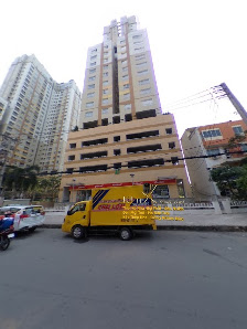 The image shows a street scene in Thao Dien, Saigon featuring a yellow delivery truck parked on the side of the road with high-rise buildings and othe
