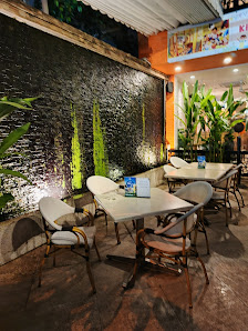 The image depicts the interior of a venue in Thao Dien, Saigon. It features several white tables with matching chairs arranged around a large, illumin
