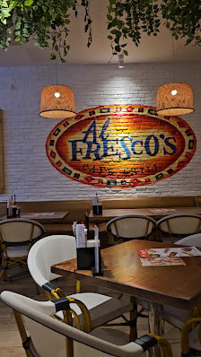 The image depicts the interior of Fresco's restaurant in Thao Dien, Saigon. It features a brick wall backdrop with a large oval sign displaying "Fresc