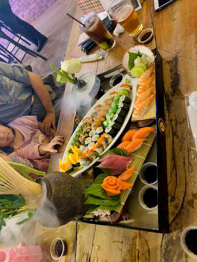 The image shows a dining table in an indoor setting at Thao Dien, Saigon with various dishes and drinks laid out for consumption.