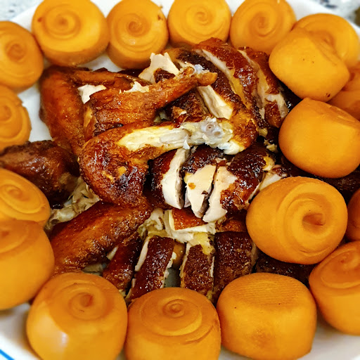 The image shows a plate of food consisting of golden-brown fried chicken pieces and round orange items that appear to be some kind of dessert or snack