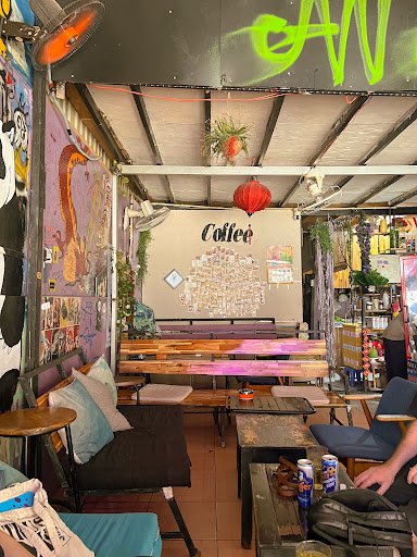 This image depicts an interior view of a casual coffee shop or lounge area in Thao Dien, Saigon. The space is adorned with various decorations includi