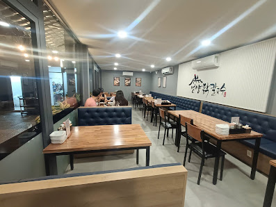 The image shows an interior view of a modern restaurant or cafe in Thao Dien, Saigon. The space is well-lit with recessed lighting and features wooden