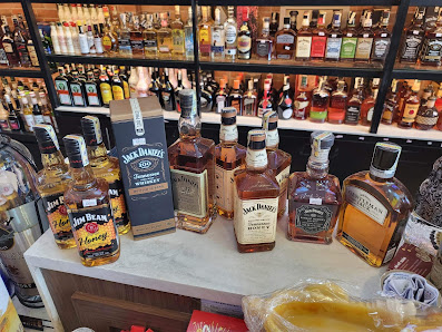 A bar counter displaying various bottles of whiskey and bourbon brands such as Jack Daniel's, Jim Beam, and Maker's Mark.