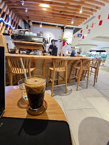 The image shows an interior view of a modern coffee shop or bar in Thao Dien, Saigon. The establishment has wooden furniture and decor with visible li