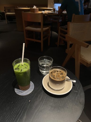 The image shows a table in an indoor setting that appears to be part of a café or restaurant with modern furniture and dim lighting, creating a cozy a