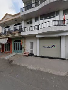 The image shows an exterior view of a two-story building in Thao Dien, Saigon with multiple balconies and commercial establishments on the ground floo