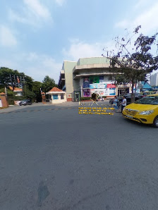 The image depicts a street intersection in Thao Dien, Saigon. A yellow taxi is parked on the right side of the paved road. In the background, there is