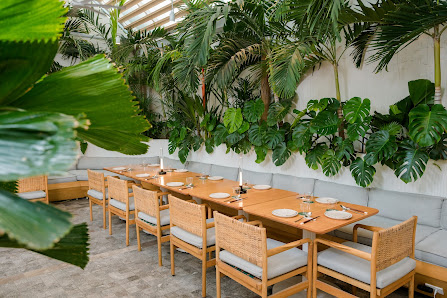 The image shows a dining area in an upscale restaurant or cafe located at Thao Dien, Saigon. The setting features a long wooden table with matching ch