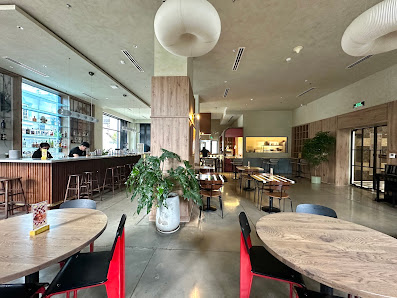 The image shows an interior view of a modern restaurant or cafe in Thao Dien, Saigon. The space is well-lit with natural light coming through the wind