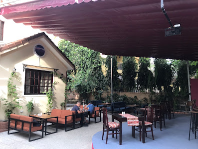 The image shows an outdoor seating area of a restaurant or café in Thao Dien, Saigon. The setting includes red and brown chairs arranged around tables