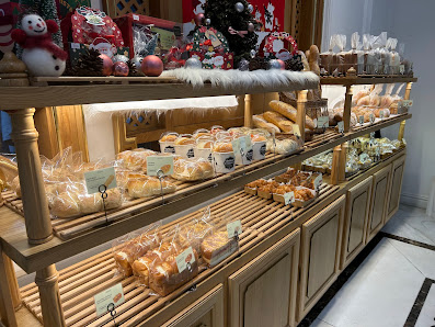 The image shows a display case in an interior setting, likely within a cafe or bakery. The shelves are filled with various baked goods such as pastrie