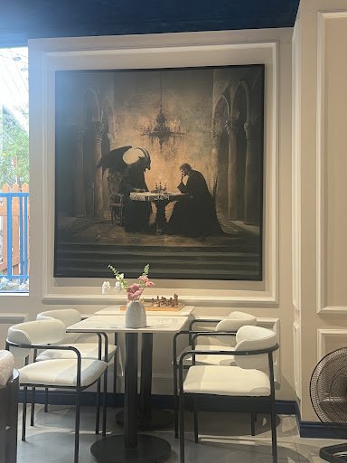 The image shows an interior space featuring a large painting depicting two figures in what appears to be a medieval or gothic setting, with one figure