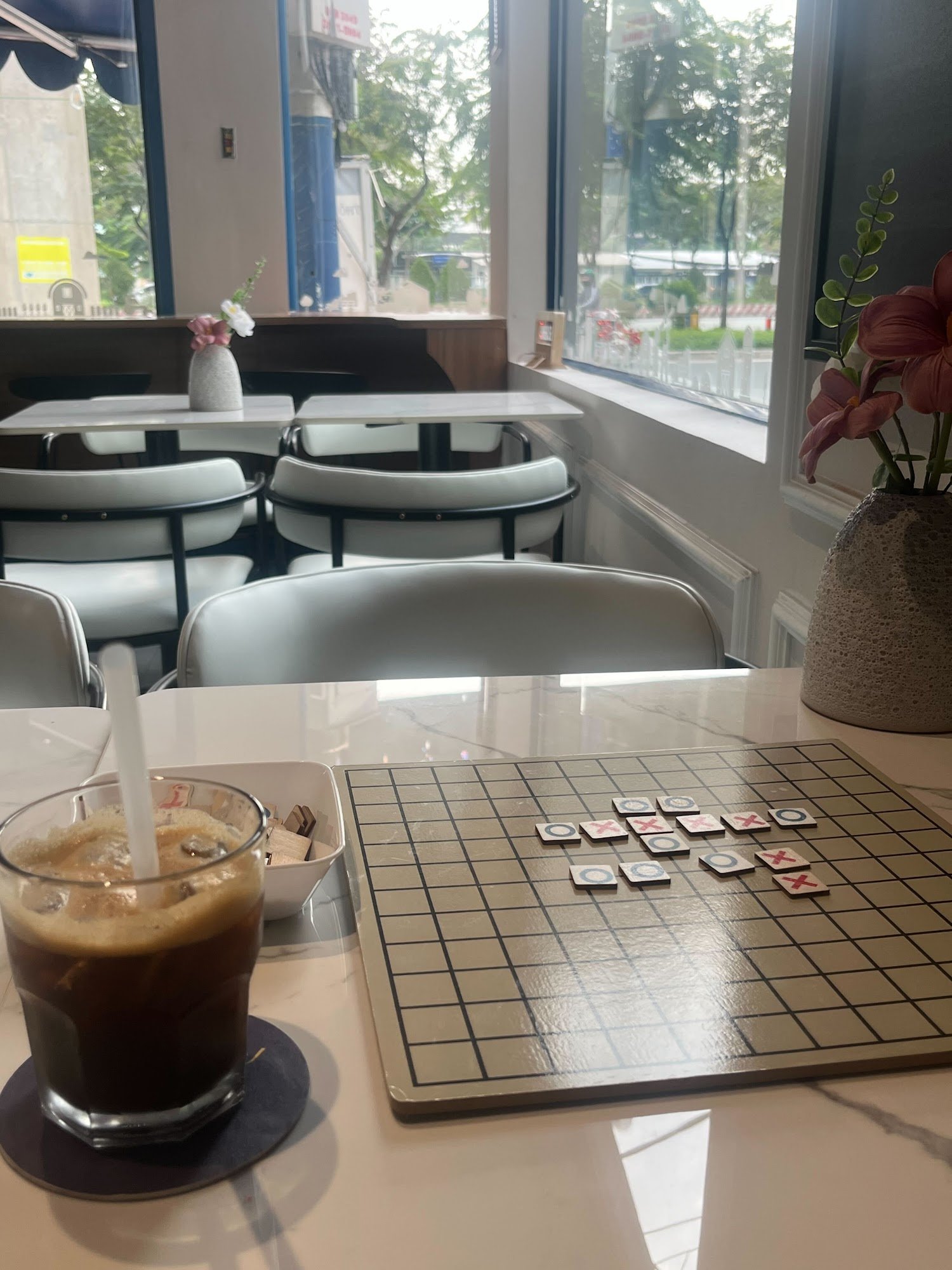 The image shows an indoor setting of a cafe or restaurant in Thao Dien, Saigon with modern decor and seating arrangements.