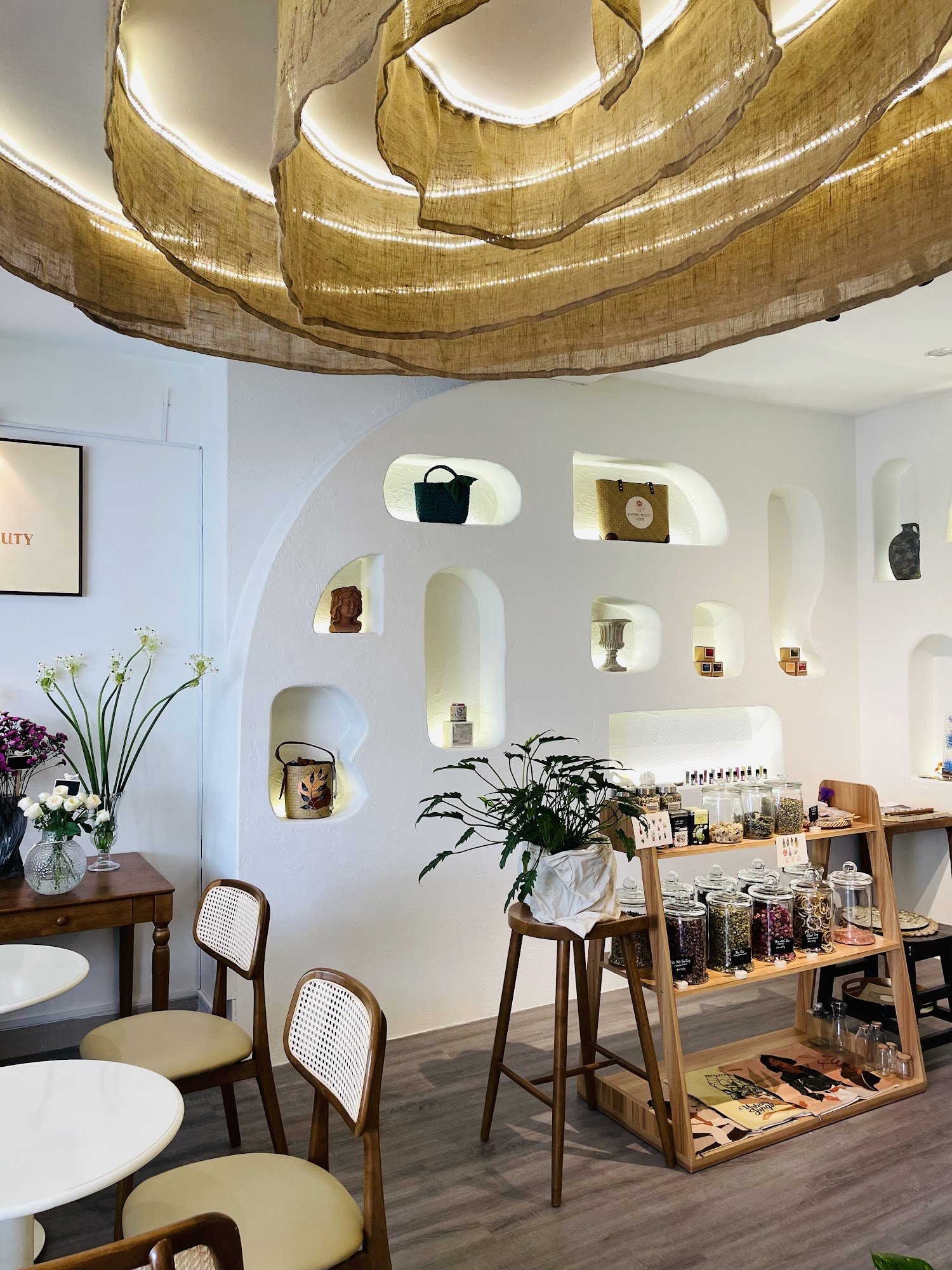 The image depicts an interior space that appears to be a boutique or small shop within Thao Dien, Saigon. The design is modern and minimalist with whi