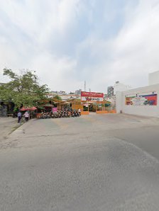 The image depicts an outdoor street scene in Thao Dien, Saigon. A paved road with a few pedestrians is visible. On the right, a white building feature