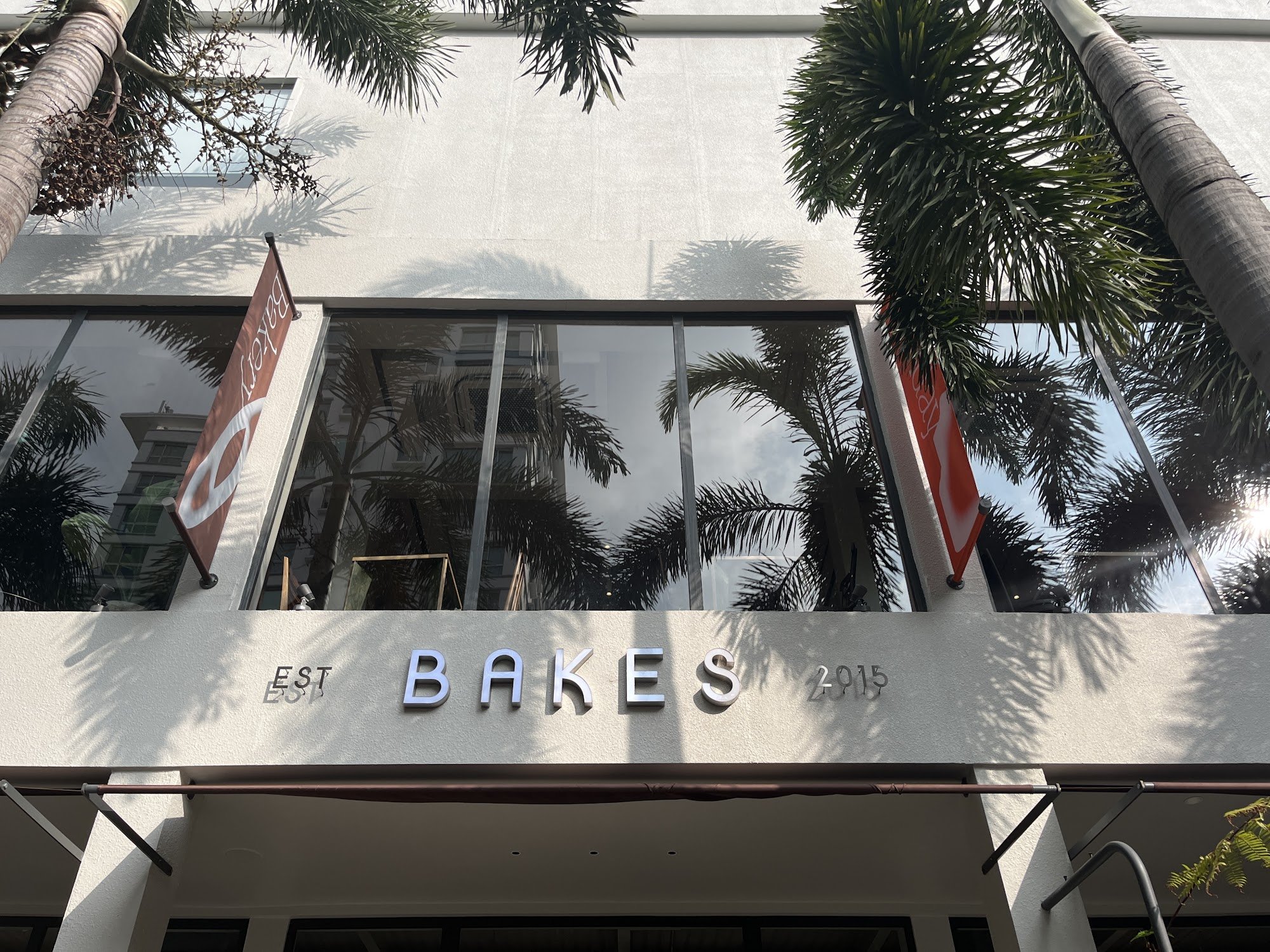 The image depicts the exterior facade of a venue named 'BAKES' established in 2015, located in Thao Dien, Saigon. The building features a light-colore