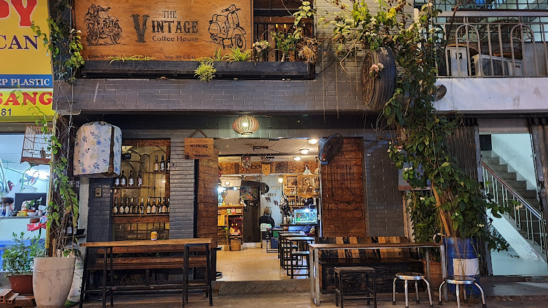 The image depicts the exterior of 'The Vintage Coffee House' in Thao Dien, Saigon. It features a two-story building with a brick facade. The ground fl
