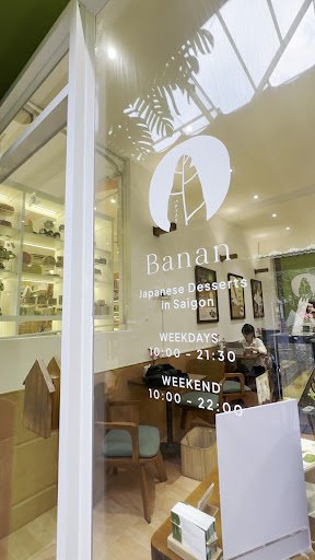 The image shows an interior view of a Japanese dessert shop named 'Banan' located in Saigon. The store has modern decor with wooden furniture and shel