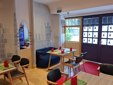 The image shows an interior view of a dining area in Thao Dien, Saigon with modern decor featuring blue and red seating arrangements.
