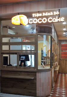 The image shows an exterior view of a food establishment named 'Coco Coke' with the name displayed prominently above its entrance.