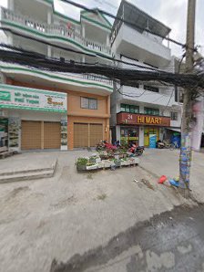 The image shows a street view of an urban area with multiple buildings and storefronts including a convenience store named 'HE MART'. There are severa