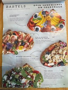A menu page from a cookbook or restaurant featuring open sandwiches on sourdough bread with various toppings such as fruits and vegetables, labeled un