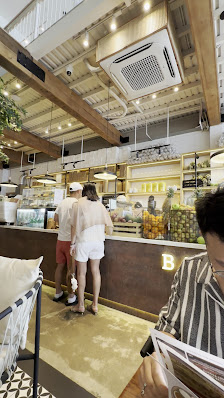 The image shows an interior view of a modern cafe or restaurant in Thao Dien, Saigon. The space is well-lit with natural light coming through the wind