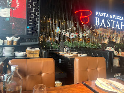The image shows an interior view of a restaurant named 'Basta' which specializes in pasta and pizza.