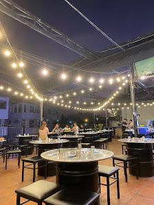 The image shows an outdoor dining area at night in Thao Dien, Saigon. The venue is adorned with string lights that create a warm and inviting atmosphe