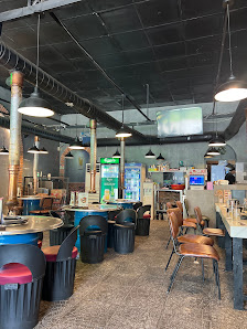 The image depicts the interior of a modern restaurant or café in Thao Dien, Saigon. It features an industrial-style design with exposed ceiling beams 