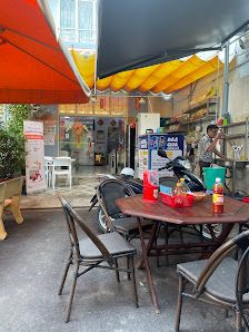 The image shows an outdoor seating area of a restaurant or cafe in Thao Dien, Saigon. There are tables and chairs arranged under large umbrellas provi