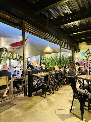 The image depicts the interior of a restaurant or café in Thao Dien, Saigon. It features an open-air layout with a mix of indoor and outdoor seating. 