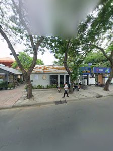 The image shows an exterior view of a street corner in Thao Dien, Saigon with various establishments including a restaurant and shops.