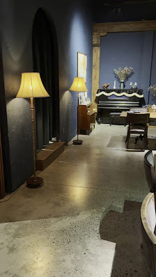The image shows an interior space of a venue in Thao Dien, Saigon with modern decor and lighting fixtures including floor lamps.