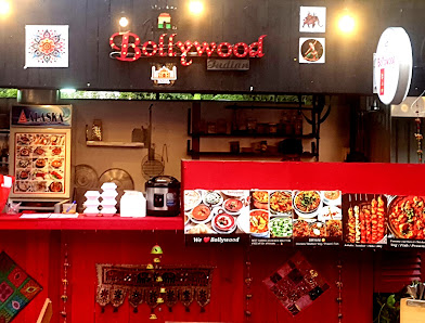 The interior of a restaurant named 'Bollywood' featuring red and black decor elements with various food items displayed on the counter.